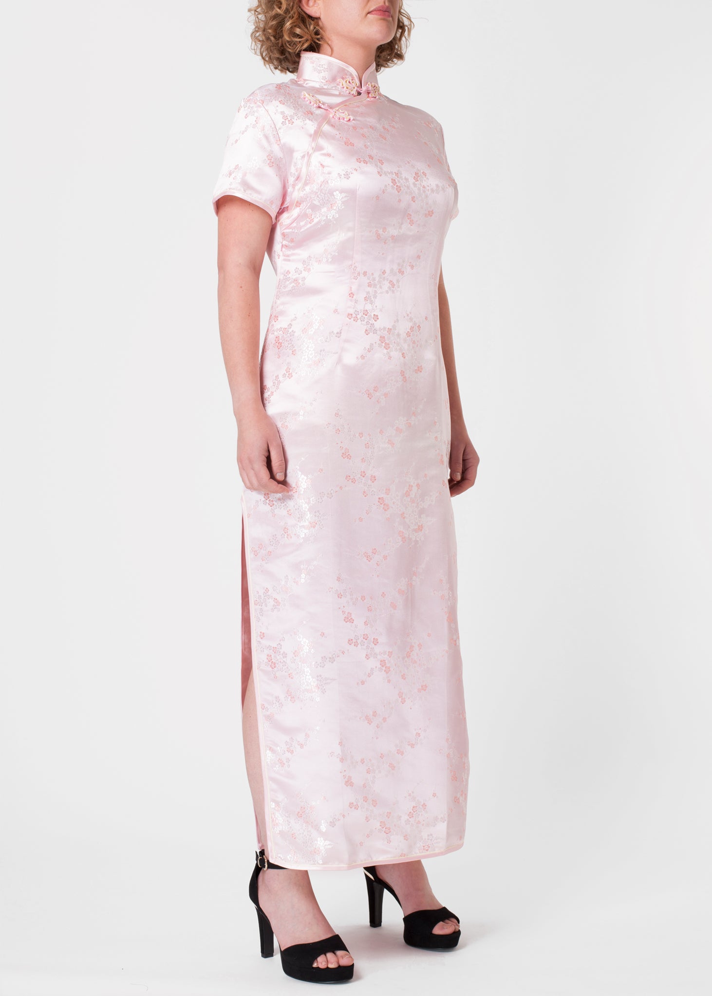The Cheongsam or Qipao, is a feminine body-hugging dress with distinctive Chinese features of mandarin collar, side splits and hand stitched flower and knot frog fastenings. Manufactured in authentic high quality silk/rayon brocade in a beautiful subtle pink cherry blossom design - a symbol of female beauty and love