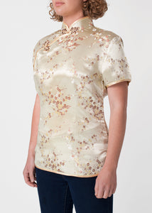 Traditional Chinese blouse in Cheongsam or Qipao style with distinctive Chinese features of mandarin collar, hand stitched flower and knot frog fastenings and side zip. Manufactured in authentic high quality silk/rayon brocade in a classic gold cherry blossom design - a symbol of female beauty and love.