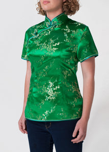 Traditional Chinese blouse in Cheongsam or Qipao style with distinctive Chinese features of mandarin collar, hand stitched flower and knot frog fastenings and side zip. Manufactured in authentic high quality silk/rayon brocade in a emerald green with gold cherry blossom design - a symbol of female beauty and love.