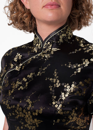 Bound edge mandarin collar and aysmmetric fastening which closes with hand stitched flower and knot frog fastenings in an accent shade. Open ended side zip and press studs