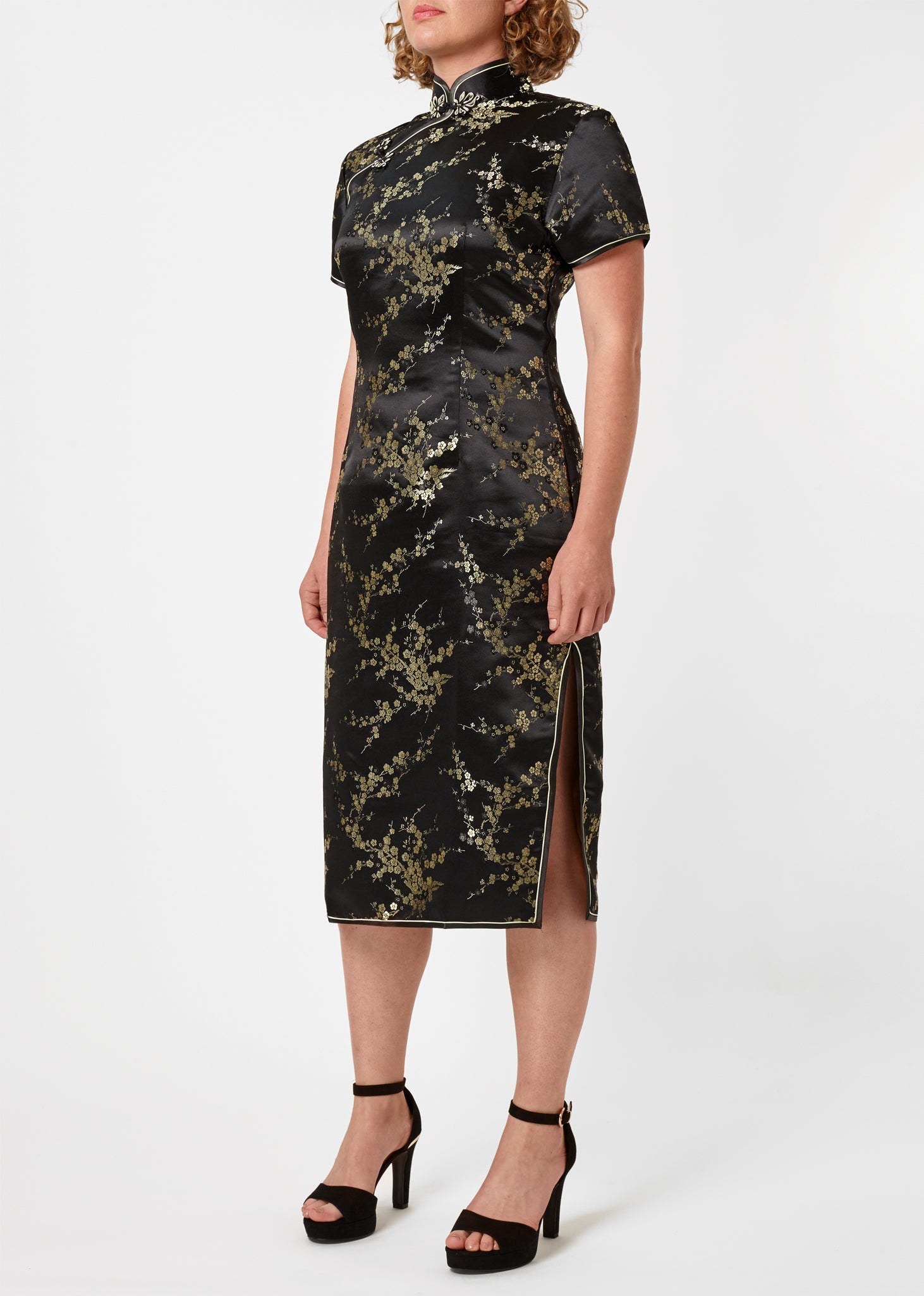 The Cheongsam or Qipao, is a feminine body-hugging dress with distinctive Chinese features of mandarin collar, side splits and hand stitched flower and knot frog fastenings. Manufactured in authentic high quality silk/rayon brocade in black with gold cherry blossom design - a symbol of female beauty and love.