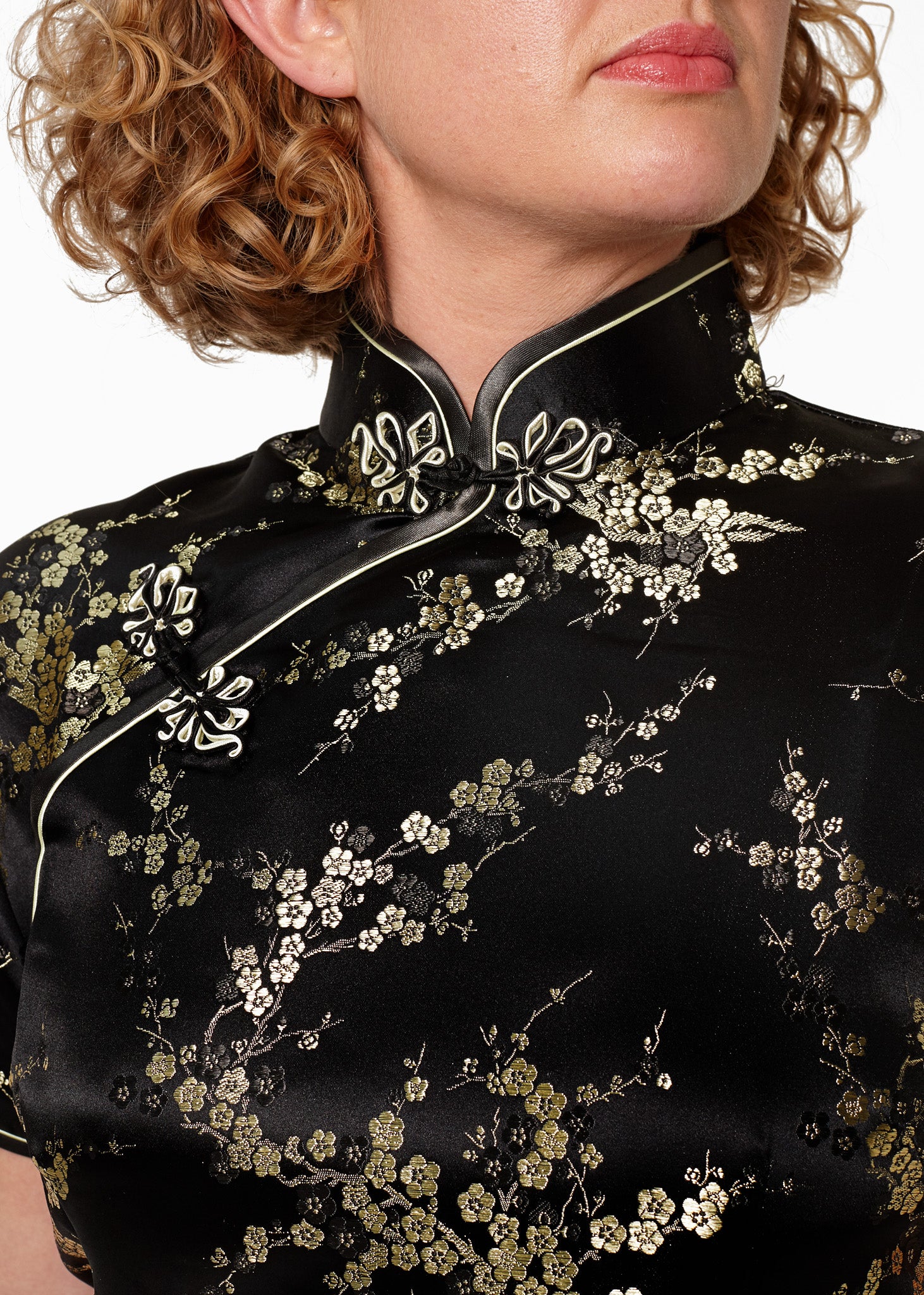 Bound edge mandarin collar and aysmmetric fastening which closes with hand stitched flower and knot frog fastenings in an accent shade