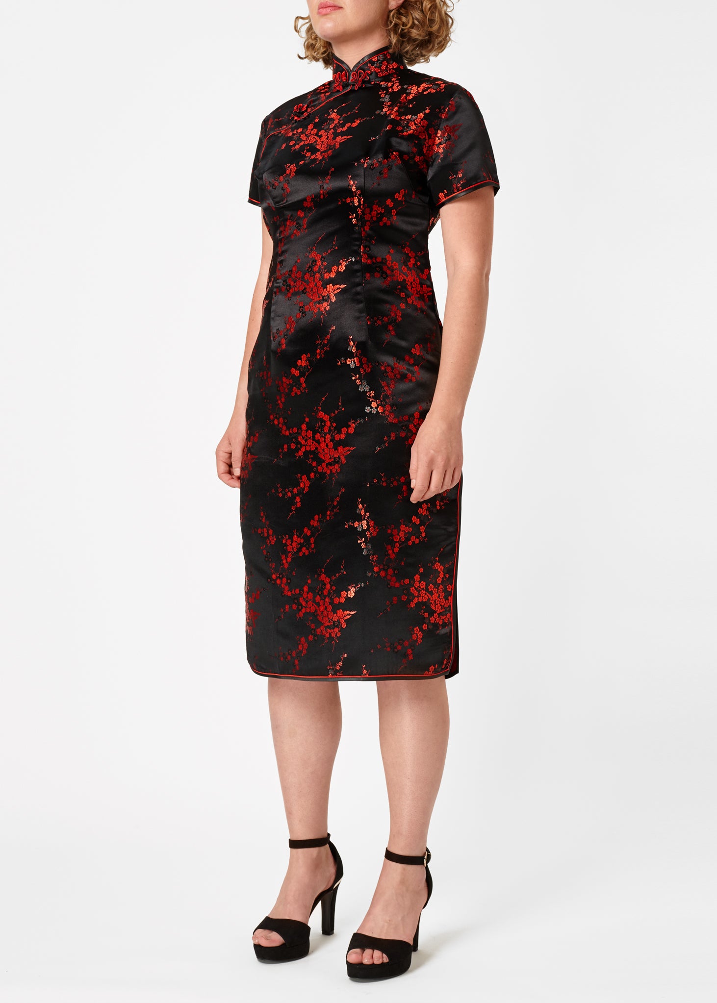 The Cheongsam or Qipao, is a feminine body-hugging dress with distinctive Chinese features of mandarin collar, side splits and hand stitched flower and knot frog fastenings. Manufactured in authentic high quality silk/rayon brocade in black with red cherry blossom design - a symbol of female beauty and love.