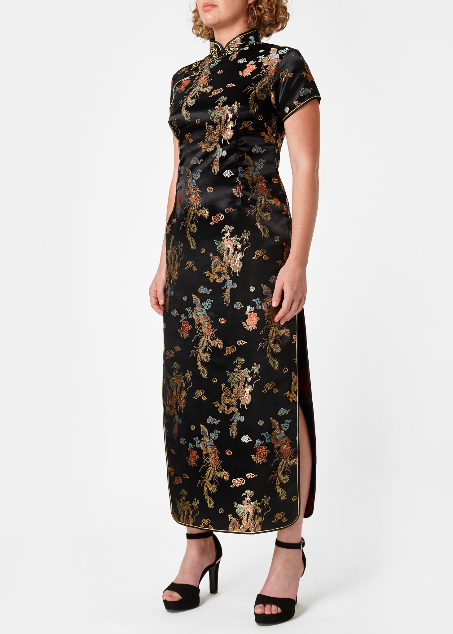 The Cheongsam or Qipao, is a feminine body-hugging dress with distinctive Chinese features of mandarin collar, side splits and hand stitched flower and knot frog fastenings. Manufactured in authentic high quality silk/rayon brocade in a sophisticated black dragon and phoenix design - a symbol of success and prosperity 