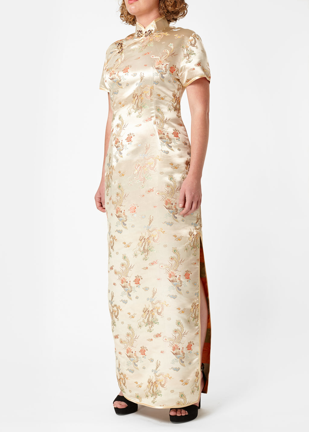 The Cheongsam or Qipao, is a feminine body-hugging dress with distinctive Chinese features of mandarin collar, side splits and hand stitched flower and knot frog fastenings. Manufactured in authentic high quality silk/rayon brocade in a classic gold dragon and phoenix design - a symbol success and prosperity